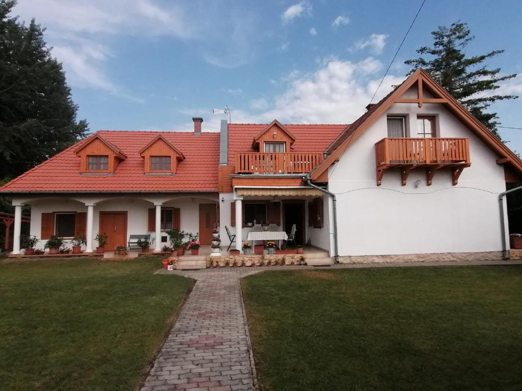 una gran casa blanca con techo rojo en Tamás Bátya Kunyhója en Balatonmáriafürdő