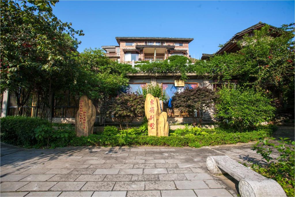 a building with gravestones in front of a yard at Riverside Retreat Hotel in Yangshuo