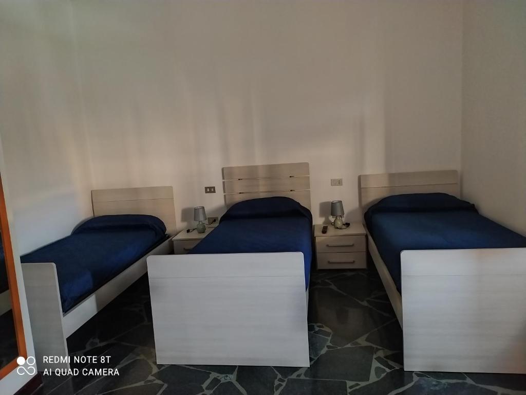 2 camas en una habitación con sábanas azules en CASA VACANZE LUNA, en Seriate