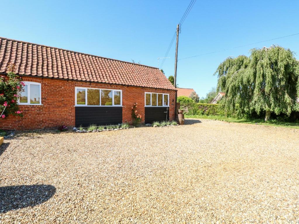 uma casa de tijolos vermelhos com uma grande entrada em The Duck House em Thetford