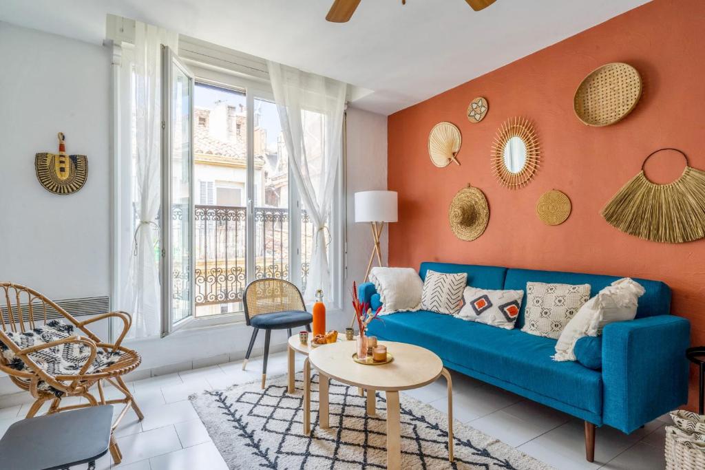 - un salon avec un canapé bleu et un mur orange dans l'établissement Appartement Liberty - Welkeys, à Marseille
