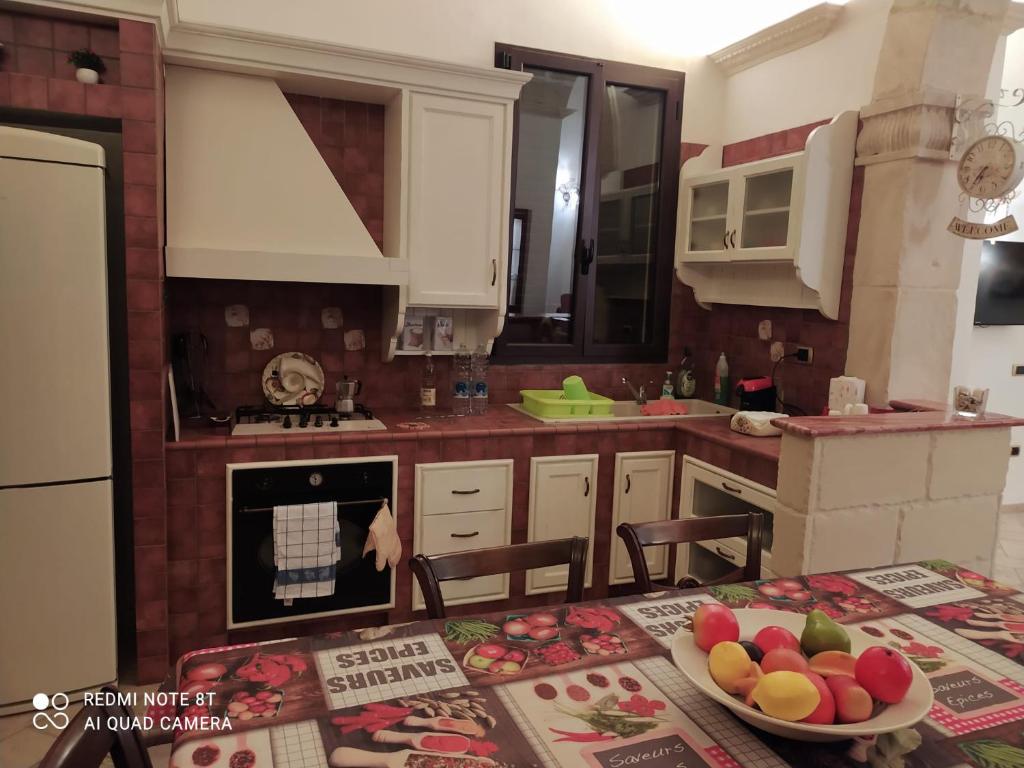 uma cozinha com uma mesa com uma taça de fruta em La casa nel borgo em Acaya