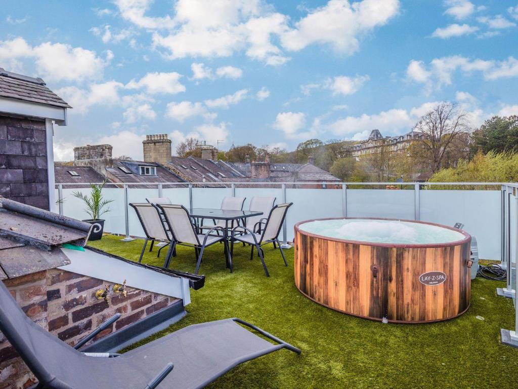 a patio with a table and chairs and a tub at The Rooftop in Buxton