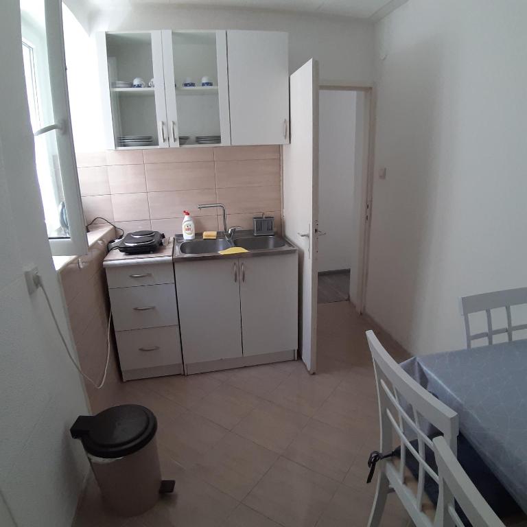 a small kitchen with a sink and a table at Vicky Apartments in Kotor