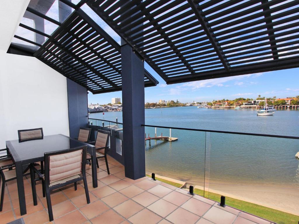 a balcony with a table and chairs and a view of the water at Kirribilli 13 in Mooloolaba