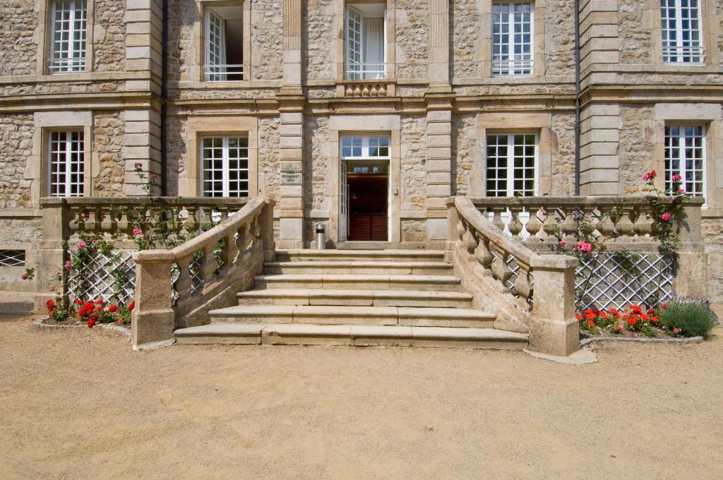 a stone building with stairs leading to a door at Domaine De Barres in Langogne