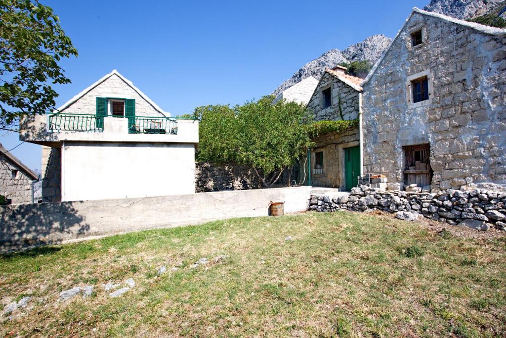 an old stone house with a stone wall at House Tina in Omiš
