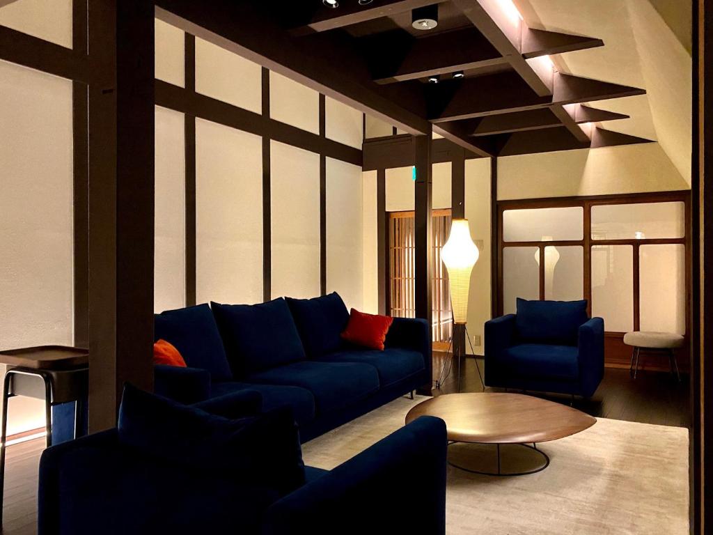 a living room with a blue couch and chairs at Sankoku Bashira in Kyoto