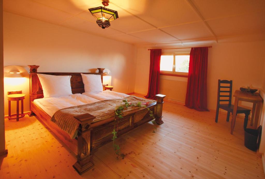 a bedroom with a bed and a table and a window at Hotel Sternen - Anno 1769 in Todtnauberg
