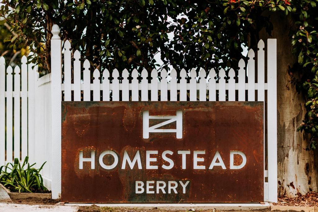 Una valla blanca con un letrero que lee bayas homestead en The Homestead en Berry