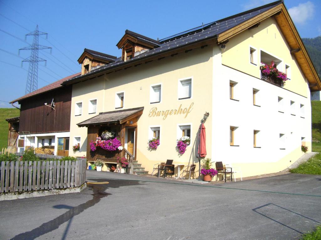 a large white building with flowers on the windows at Burgerhof in Pettneu am Arlberg
