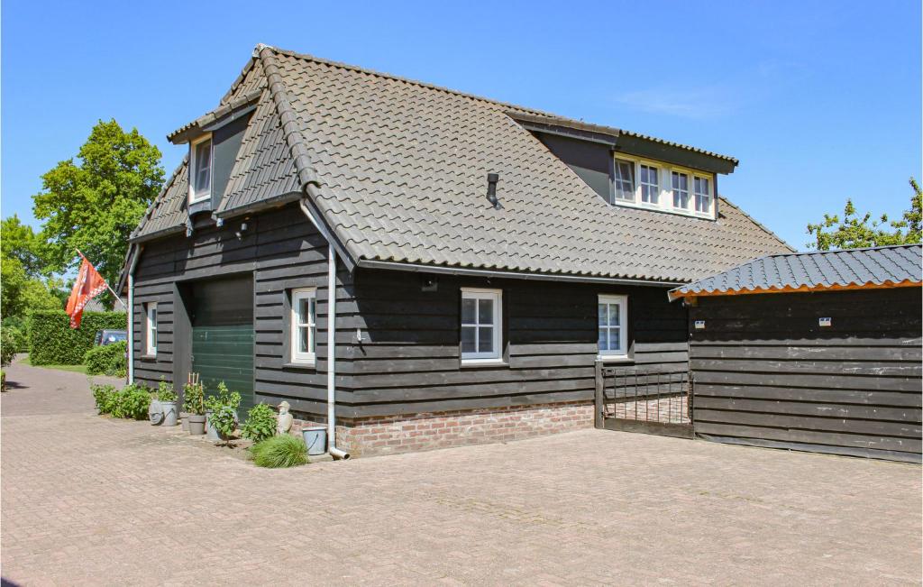 una casa negra con un garaje delante en Awesome Home In Udenhout With House A Panoramic View, en Udenhout