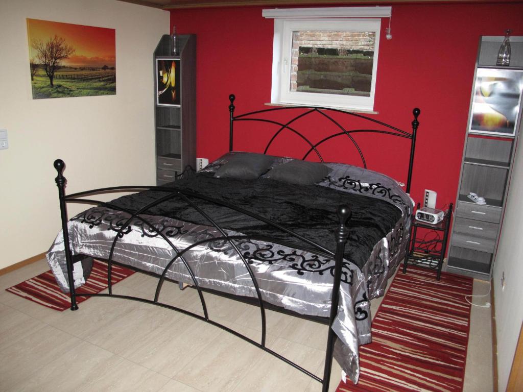 Un dormitorio con una cama negra en una pared roja en Nettetal - free2beme, en Nettetal