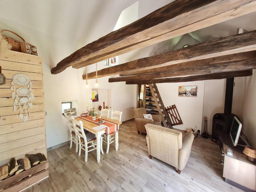 een woonkamer met een tafel en stoelen en een trap bij House "Ranná Rosa" - Holidayfarm Natural Slovakia in Modrý Kameň