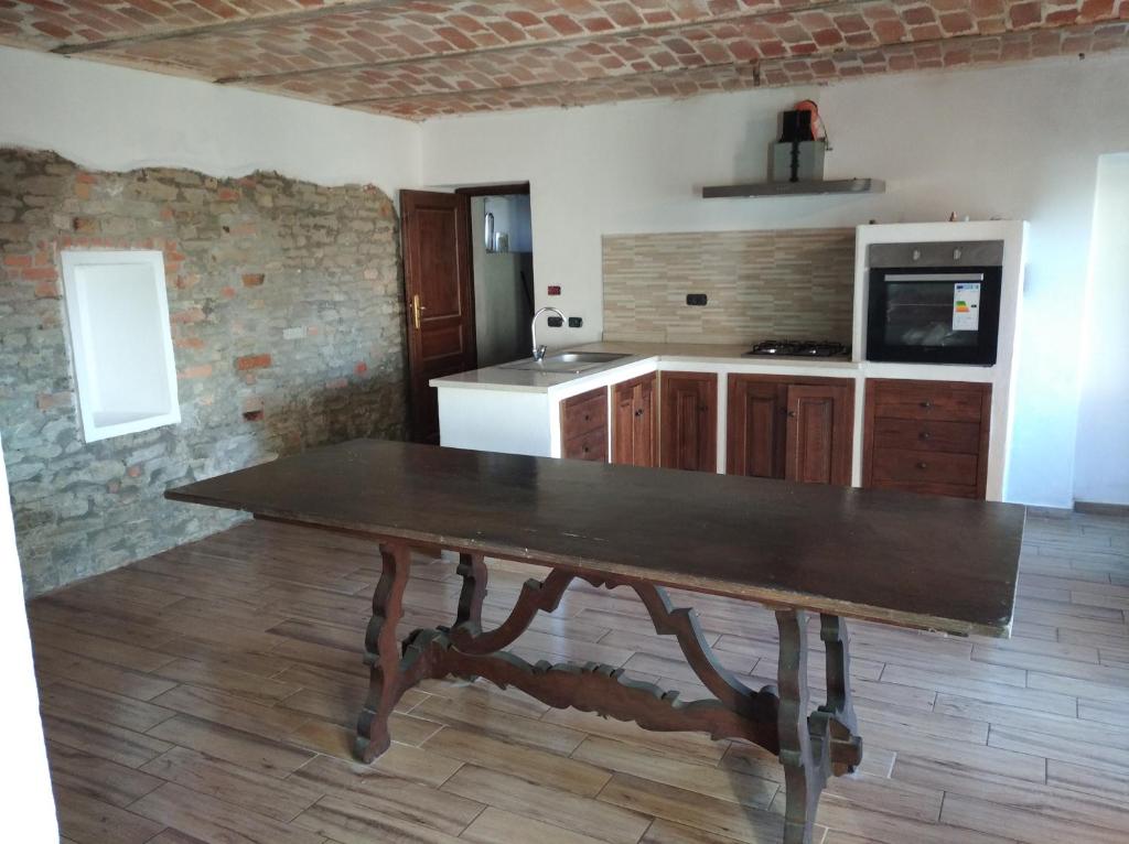 uma cozinha com uma mesa de madeira num quarto em cascina carlo em Aie