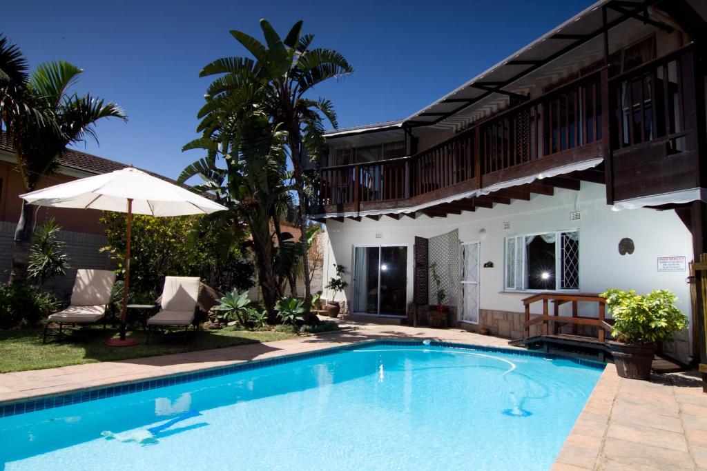 a swimming pool in front of a house at Boma Lodge in Durban