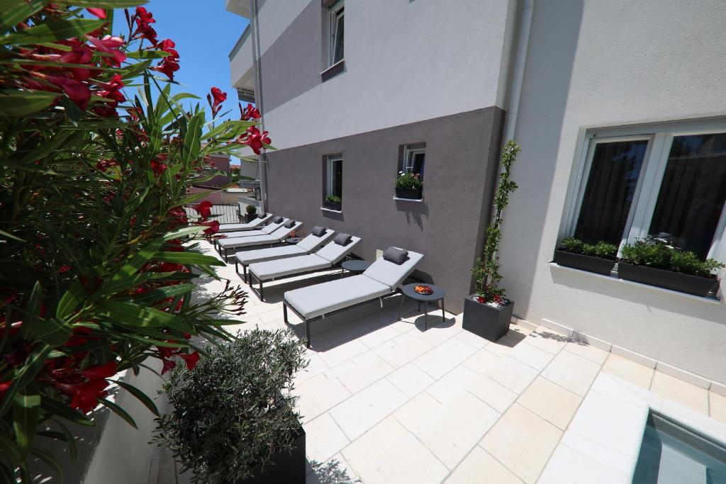 a row of white chairs sitting on a courtyard at Apartments Lace in Novalja