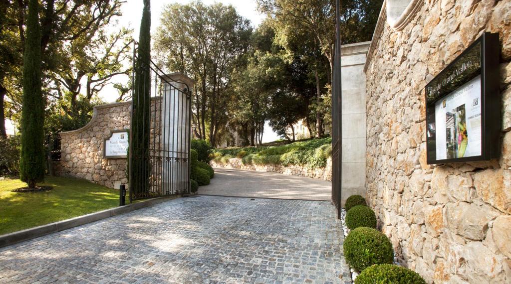 a stone house with a gate and a driveway at Résidence Hôtelière 4 étoiles Les Mas du Grand Vallon in Mougins