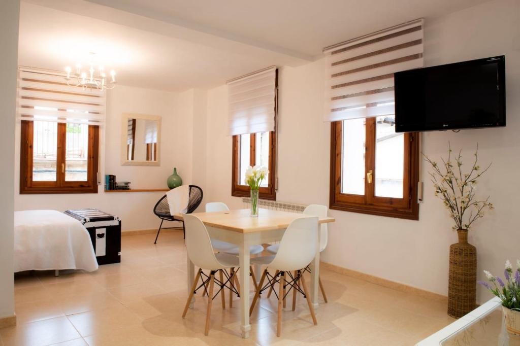 Apartamento La Placeta في مونرويو: غرفة معيشة مع طاولة وكراسي وسرير