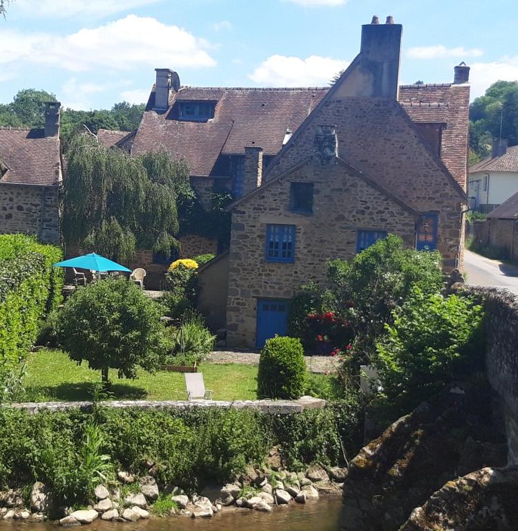 une ancienne maison en pierre au milieu d'une rivière dans l'établissement Gite du Pont Saint-Céneri-Le-Gérei dans les Alpes Mancelles, à Saint-Céneri-le-Gérei