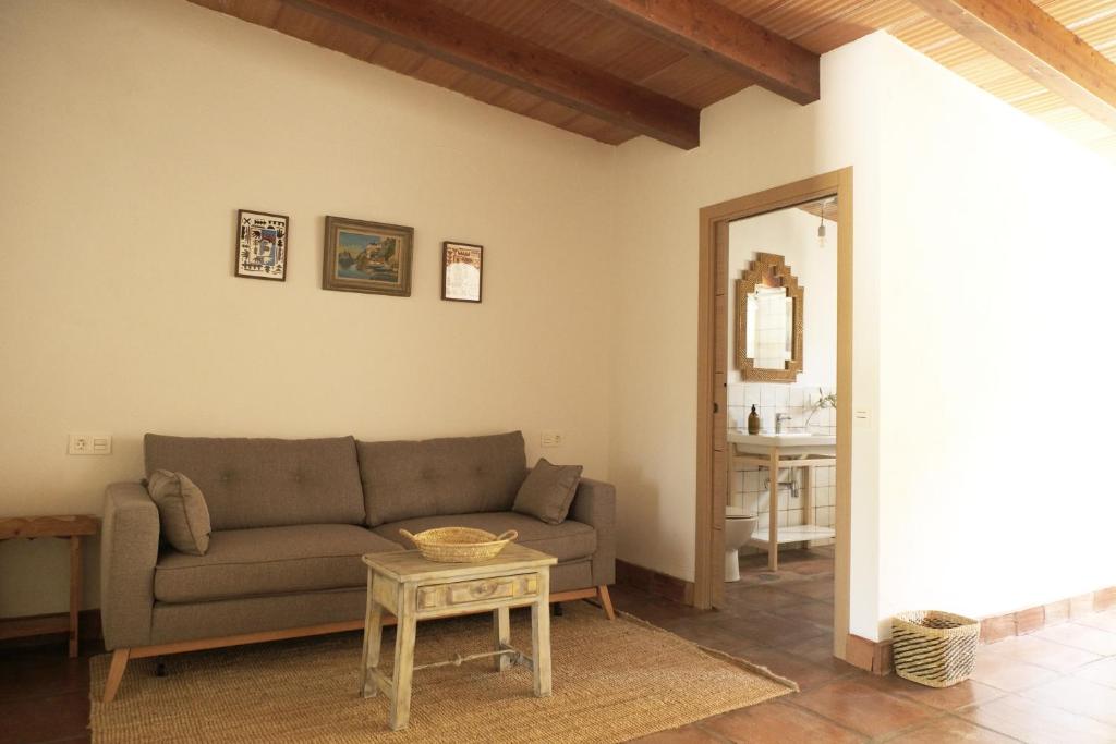a living room with a couch and a table at The Wild Olive Andalucía Palma Guestroom in Casares