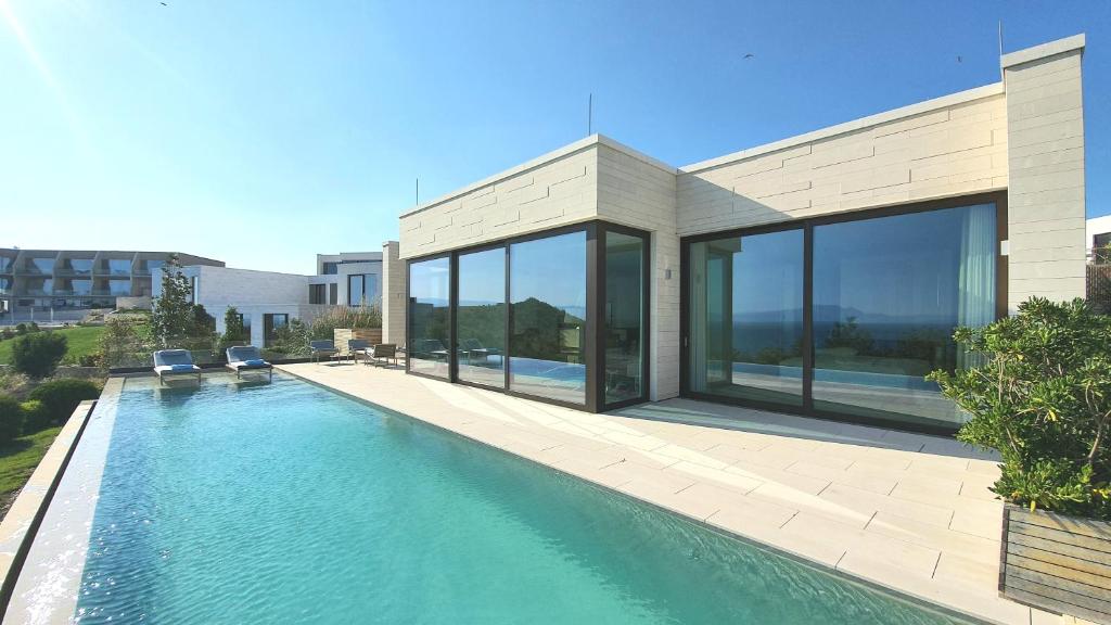a house with a swimming pool in front of it at PRIVE The Luxury Villa & Boutique Hotel, Cape of Rodon in Draç