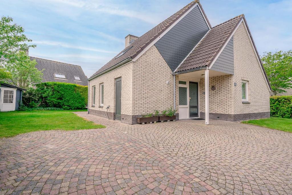 a house with a brick driveway in front of it at Villapark Kamperfoelie 49 in De Koog