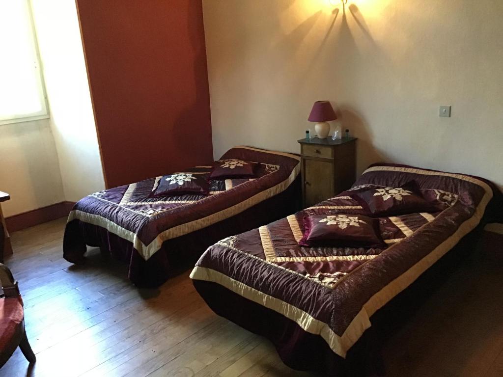 two beds in a room with a wooden floor at Maison Laclede in Bedous