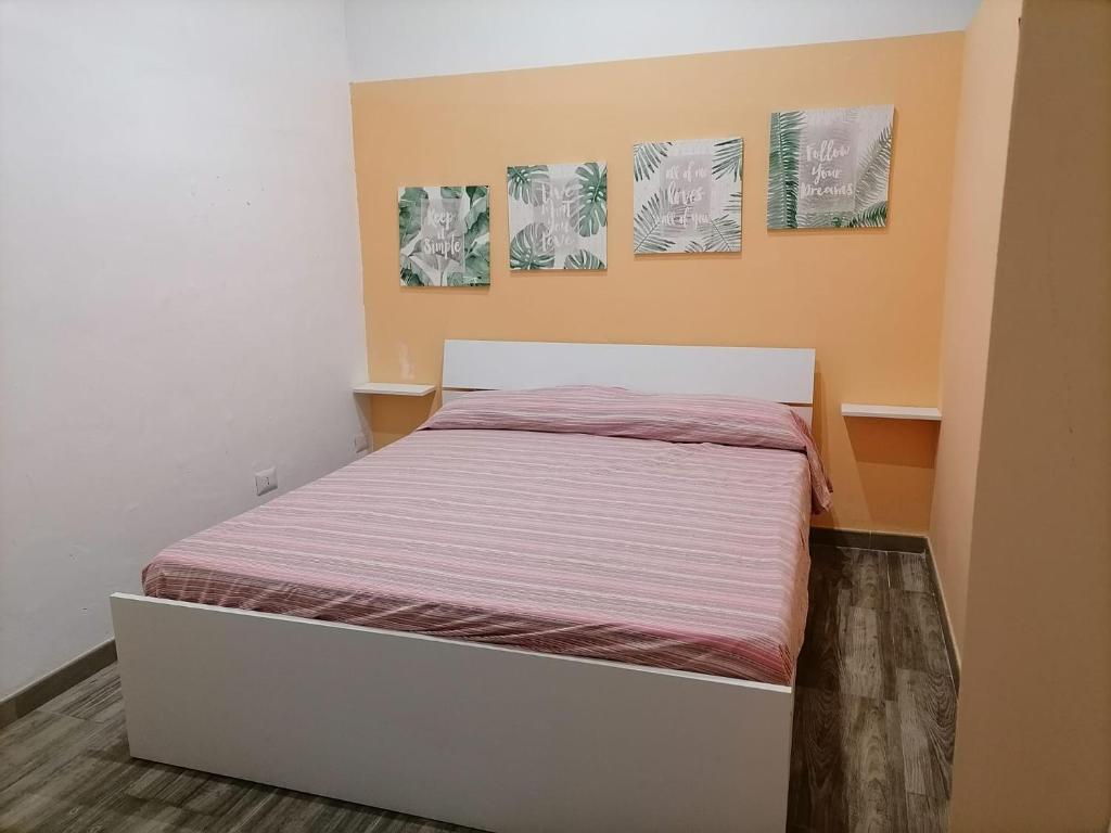 1 cama en una habitación con 3 cuadros en la pared en la casetta, en Termini Imerese
