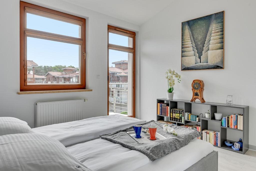 a bedroom with a bed and a book shelf at Grand Apartments - Neptun Park. in Gdańsk