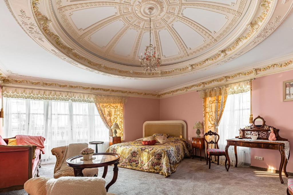 - une chambre avec un lit et un plafond à caissons dans l'établissement Hotel Usadba Maryino, à Andrianovo