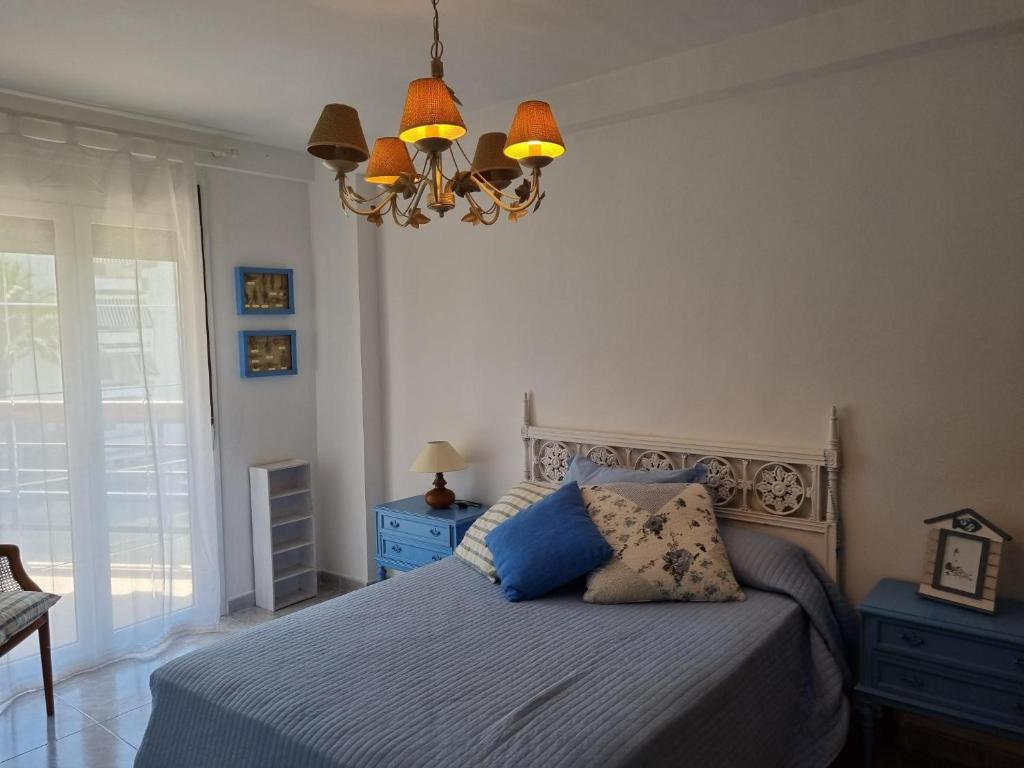 a bedroom with a bed and a chandelier at COSTA DAURADA APARTAMENTS - 174 Formentor Luxe II in Salou