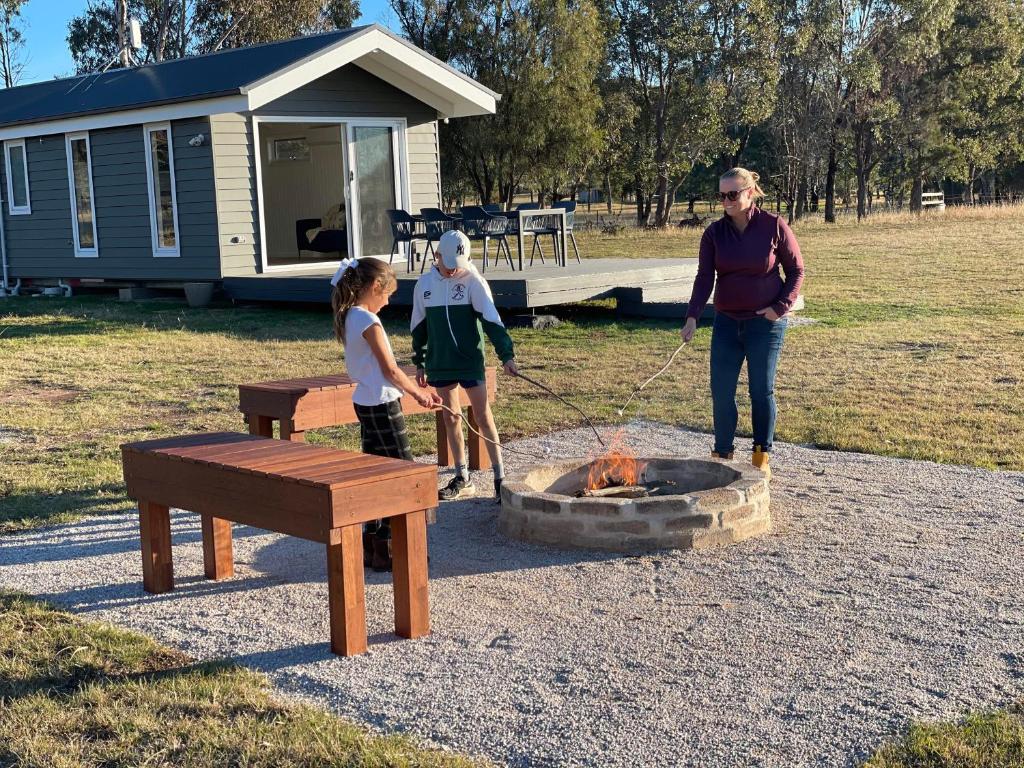 a man and two children standing around a fire pit at Wallinga Farmstay Mudgee in Mudgee