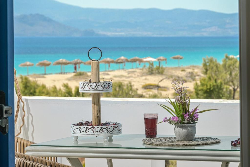 einen Tisch auf dem Balkon mit Blick auf den Strand in der Unterkunft Alykes Studios & Suites in Agios Prokopios