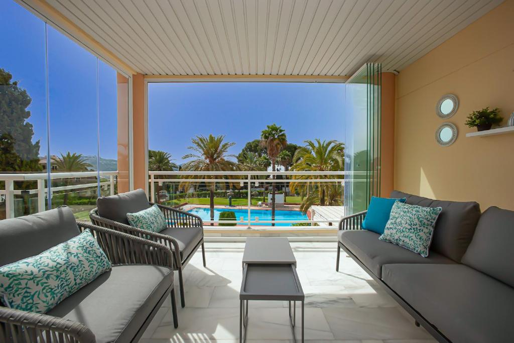 un salon avec un canapé et des chaises et une piscine dans l'établissement Las Palmeras Beach with Community Pool, à La Herradura