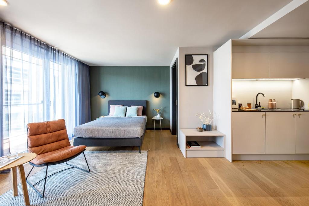 a bedroom with a bed and a chair and a kitchen at ipartment Böblingen Region Stuttgart in Böblingen