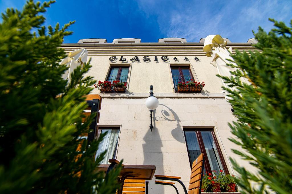 un edificio con dos ventanas y un cartel en él en Hotel Clasic en Sebeş