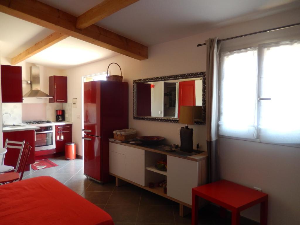 a kitchen with a red refrigerator and a red stool at Nuit calme sur domaine in Calcatoggio