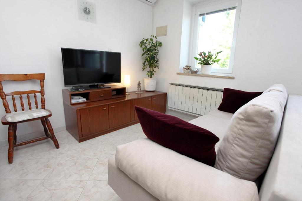 - un salon avec un canapé et une télévision dans l'établissement Apartment Gorgo, à Sečovlje