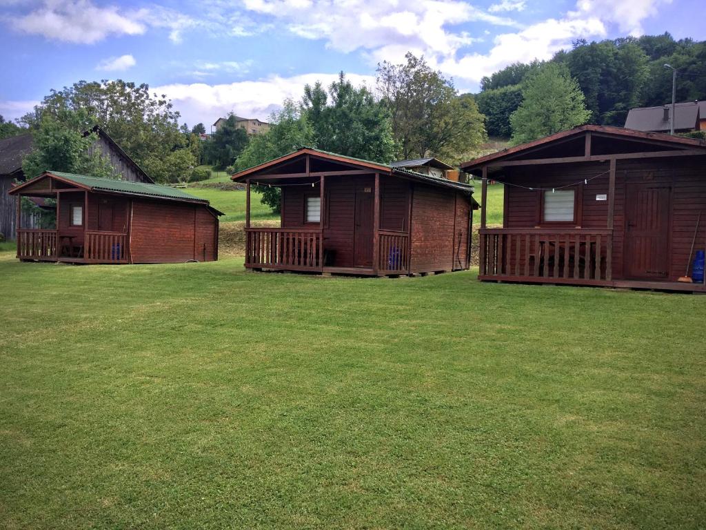 a group of huts in a field with grass at Kazikówka - Domki letniskowe w Solinie in Solina