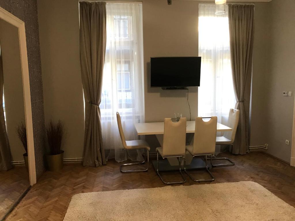 ブダペストにあるVital Apartmentのダイニングルーム(テーブル、椅子、テレビ付)