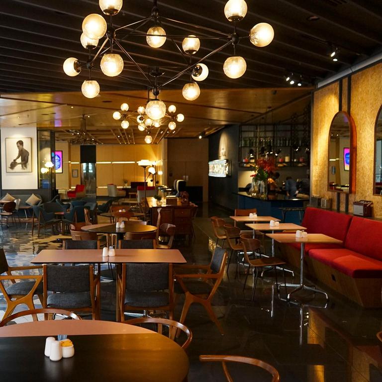 a restaurant with tables and chairs and a bar at The Kuala Lumpur Journal Hotel in Kuala Lumpur