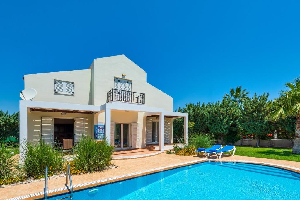 een huis met een zwembad ervoor bij Apollo Villa in Kolimbia