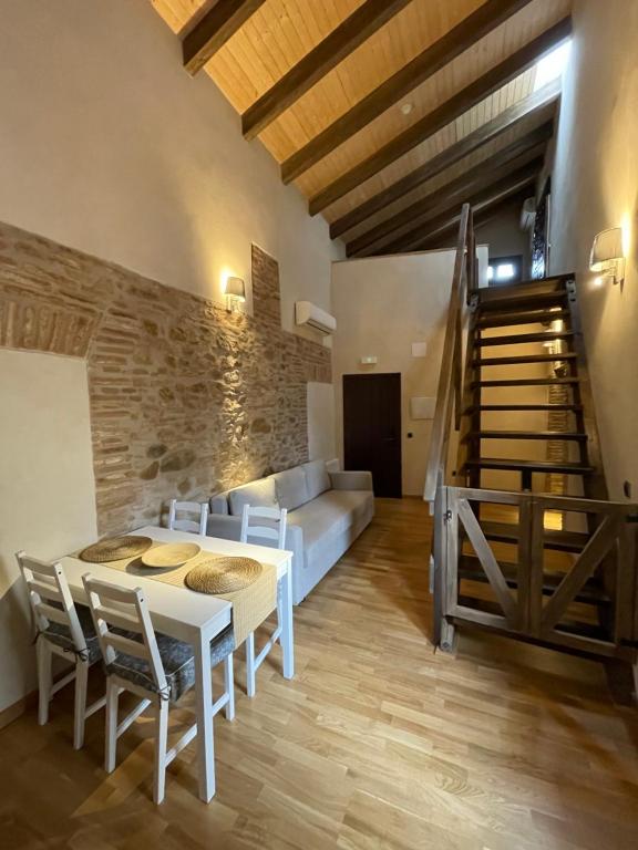 sala de estar con mesa y sofá en APARTAMENTOS RURALES POSADA DE LLERENA, en Llerena