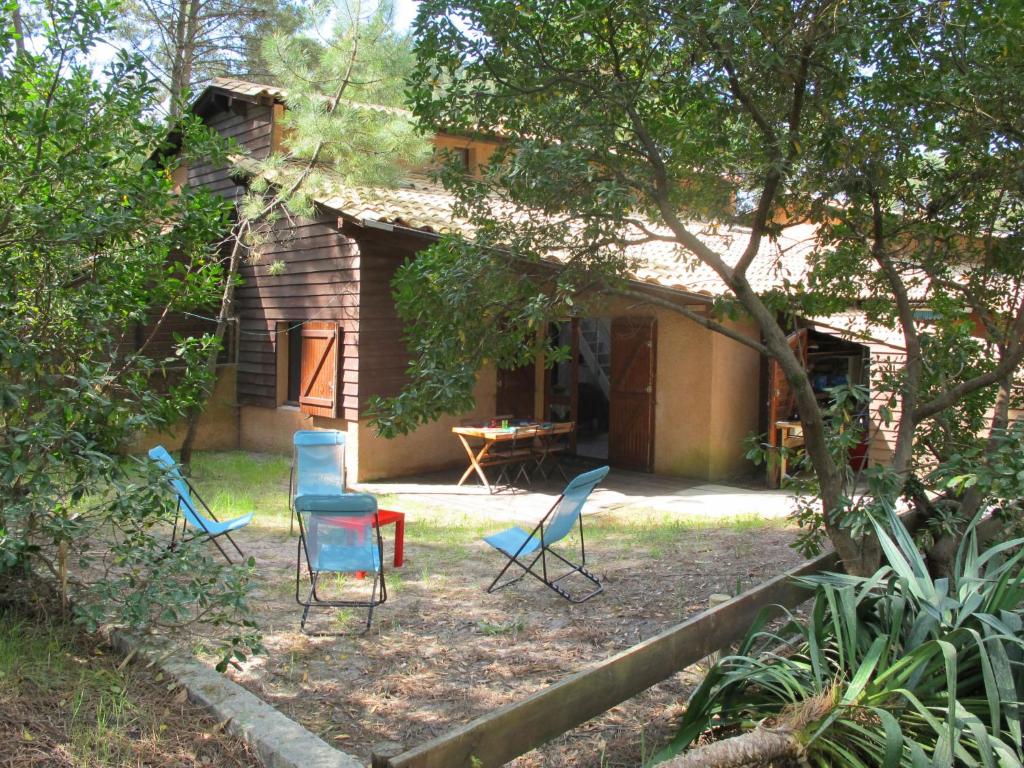 a group of chairs sitting outside of a house at Holiday Home Les maisons de la forêt by Interhome in Lacanau-Océan