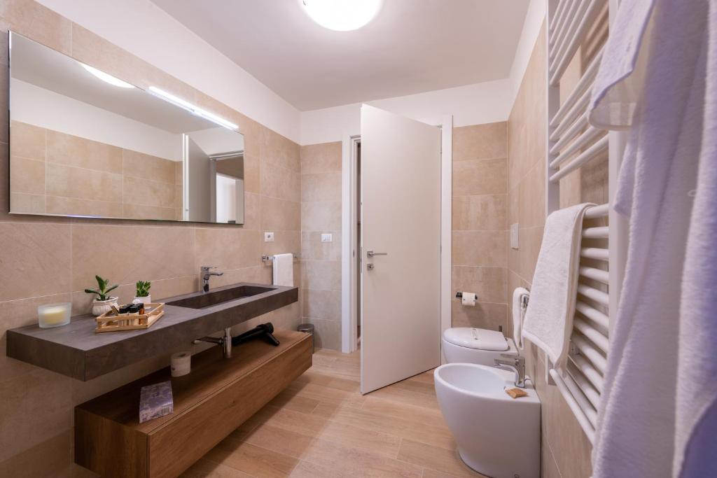 bagno con lavandino, servizi igienici e specchio di Dimora Le Volte a Lecce