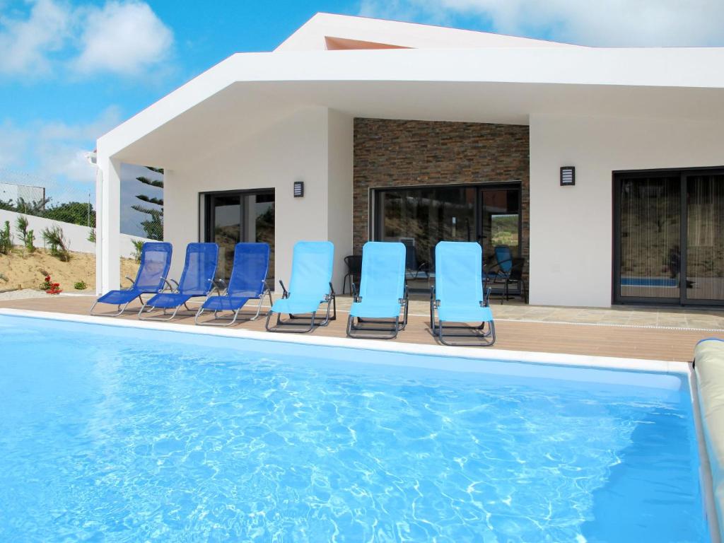a group of blue chairs sitting next to a swimming pool at Holiday Home Do Pinheiros by Interhome in Vau