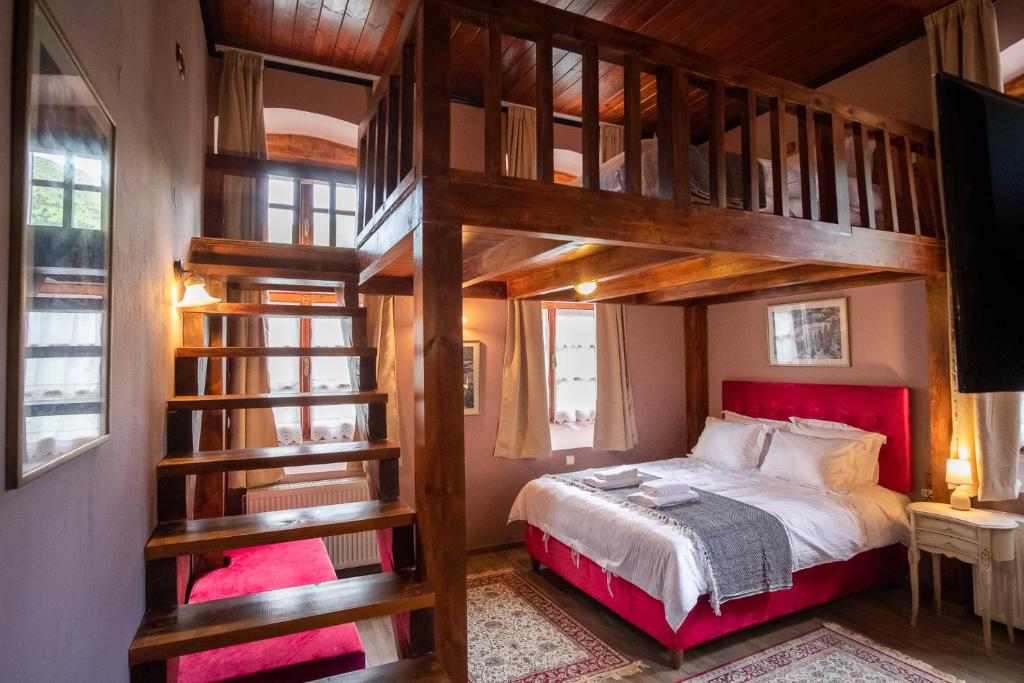 a bedroom with a bunk bed with a red headboard at The Old School Boutique Hotel in Sirako