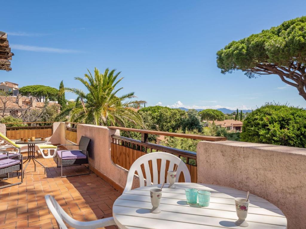 un patio avec une table et des chaises sur un balcon dans l'établissement Holiday Home Le Romarin by Interhome, aux Issambres