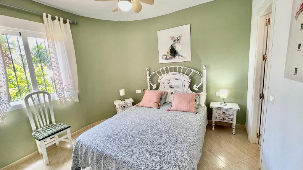 sypialnia z łóżkiem z różowymi poduszkami w obiekcie Chalet en primera Línea con 150m2 de Jardín Privado w mieście Torrox Costa